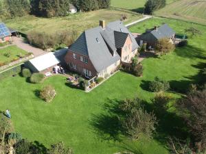 una vista aérea de una gran casa en un césped verde en Ferienhaus Addebüll, en Langenhorn