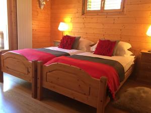 two twin beds in a room with wooden walls at Celine 9, Champery in Champéry