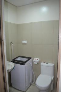 a bathroom with a white toilet and a sink at Jovic's Condo at Breeze Residences. in Manila