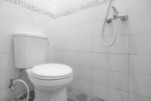 une salle de bain blanche avec toilettes et douche dans l'établissement RedDoorz near Hartono Mall, à Yogyakarta