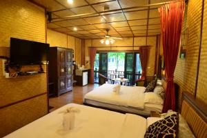 a hotel room with two beds and a television at Viang Yonok Hotel, Restaurant, Sports Club in Chiang Saen