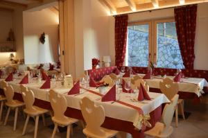 a room with long tables and chairs with red napkins at Chalet Serena in Roncegno +44 photos
