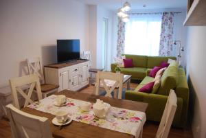 コウォブジェクにあるSpring & Summer Apartments Polanki Parkのリビングルーム(緑のソファ、テーブル付)