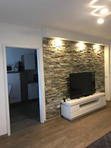 a living room with a flat screen tv on a brick wall at City Apartment in Augsburg