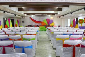 a room with white chairs and colorful decorations at Comfort Inn Donil Vadodara in Vadodara