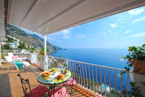 einen Balkon mit einem Tisch und Meerblick in der Unterkunft La Scaletta in Praiano