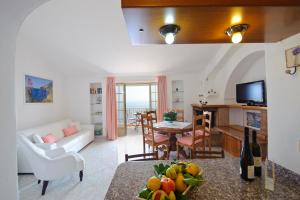プライアーノにあるLa Scalettaのリビングルーム(白いソファ、フルーツ付きのテーブル付)