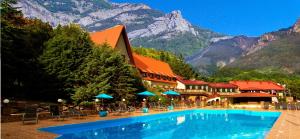 un hotel con piscina con montagne sullo sfondo di Eco Hotel Polyana Skazok a Jalta