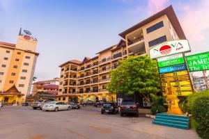 a street with cars parked in front of a building at Nova Park Hotel by Compass Hospitality in Pattaya Central