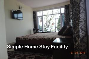 a bedroom with a bed and a window at Shimla View Home in Shimla