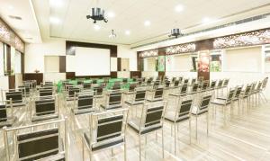 una sala de conferencias con sillas y una pantalla blanca en Treebo Trend C Plaza, en Vijayawāda
