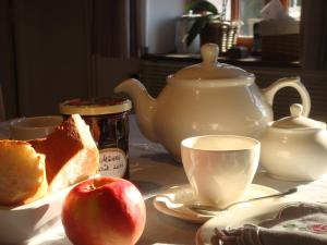 Le Bout Du Monde في Villedieu-sur-Indre: طاولة مع تفاحة وكوب من الشاي