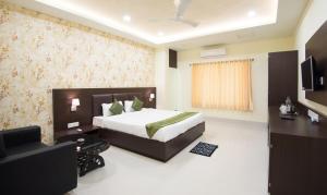 una camera d'albergo con un letto e una televisione di Treebo King'S Court Chandrasekharpur a Bhubaneshwar