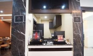 una cucina con armadi neri e bancone di Treebo King'S Court Chandrasekharpur a Bhubaneshwar