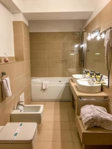 a bathroom with two sinks and a tub at Hotel Satu Mare City in Satu Mare