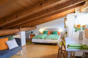 Habitación en el ático con cama y mesa en Casa al Pozzo en Riva del Garda