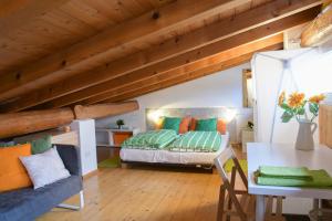 リーヴァ・デル・ガルダにあるCasa al Pozzoのベッドとテーブル付きの屋根裏部屋