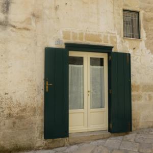 a door with green shutters on a building at Casa Elena in Matera
