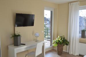 a living room with a desk and a tv on a wall at Appartement Sendenhorst in Sendenhorst