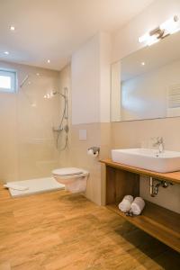 ein Badezimmer mit einem Waschbecken, einem WC und einer Badewanne in der Unterkunft Alpenhotel Regina in Nauders