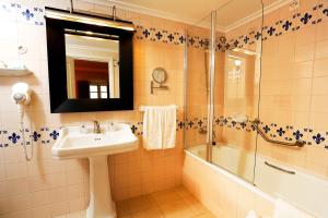 a bathroom with a toilet, sink, mirror and bath tub at Parador Casa Da Insua in Penalva do Castelo