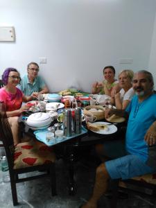 a group of people sitting around a table at i - One's Home Stay in Cochin
