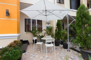 a table and chairs under an umbrella in a courtyard at RedDoorz Plus @ Boulevard Residence BSD in Tangerang