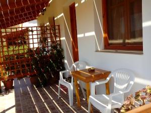 een eetkamer met witte stoelen en een tafel bij Drakano Rooms in Fanari