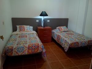 カレタ・デ・フステにあるSol y Luna en Caleta de Fusteのベッドルーム1室(ベッド2台、ドレッサー、ランプ付)