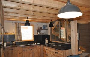 ヴァロワールにあるOdalys Chalet Le Mas des Neigesのキッチン(木製キャビネット、黒いカウンタートップ付)