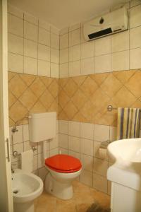 トリカーゼにあるCasa Vacanze La Corte Chiusaのバスルーム(赤いトイレ、洗面台付)