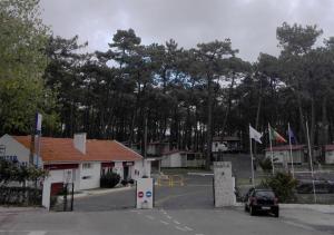 ein Auto parkt auf einem Parkplatz mit Bäumen im Hintergrund in der Unterkunft Parque de Campismo Orbitur Valado in Nazaré