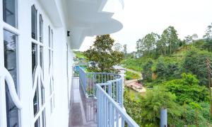 un balcone di una casa con vista sulla valle di Kurinji Wanderlust Resort Munnar a Munnar