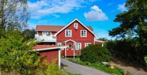 a red house with a red fence at STF Möja Vandrarhem in Möja
