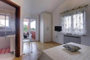 een slaapkamer met een bed, een wastafel en een raam bij Villa Delle Rondini in Krnica