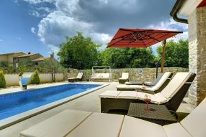 een patio met een zwembad en een rode parasol bij Villa Delle Rondini in Krnica