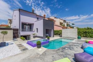 an exterior view of a house with a swimming pool at Holiday Home Moderna in Pula