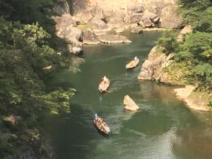 a group of people in boats on a river at kinugawaonsen Fukumatsu in Nikko