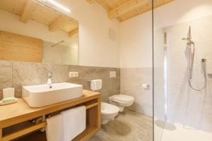 a bathroom with a sink and a toilet and a shower at Krebslechnerhof in Brunico