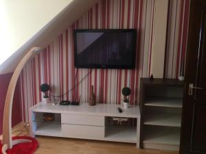 a living room with a tv on a wall at Korona Apartman in Kaposvár