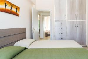 a bedroom with a bed and white cabinets at Villa Kampos in Vanáton