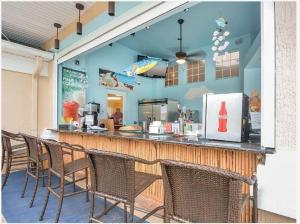 a restaurant with a counter with chairs in front of it at Resort-Style Condo Near Disney World in Kissimmee