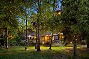 une maison avec des arbres devant elle la nuit dans l'établissement Hotel Parc Belair, à Luxembourg