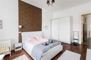 ブダペストにあるMegszűnt- BpR PureHOME Apartmentの白いベッドと木製の壁が備わるベッドルーム1室が備わります。