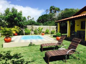 un patio con 2 sillas y una piscina en Casa Amarela na praia 14 pessoas, en Ponta da Tulha