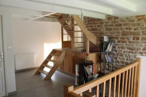 drewniane schody w pokoju z ceglaną ścianą w obiekcie Au calme w mieście Lalheue
