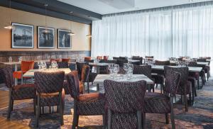 a restaurant with tables and chairs in a room at Leonardo Hotel Nottingham in Nottingham