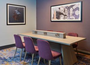 a conference room with a table and purple chairs at Leonardo Hotel Nottingham in Nottingham