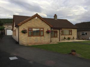 une maison en briques avec une pelouse devant elle dans l'établissement Carinya, à Talgarth