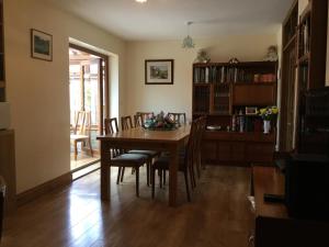 comedor con mesa de madera y sillas en Carinya en Talgarth